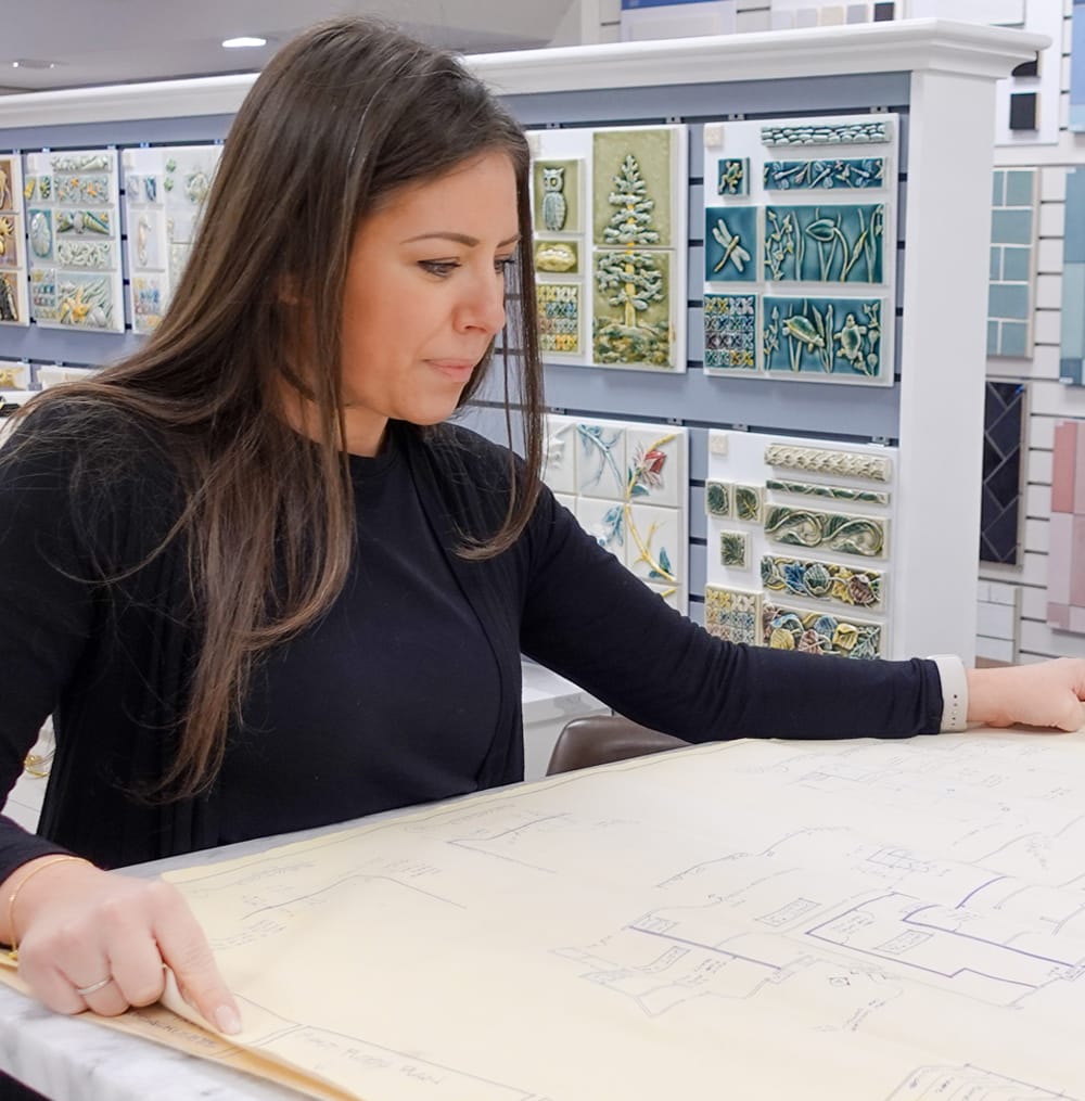 A Tile By Design employee looks at some of the high quality tile at our North Shore tile showroom in Massachusetts.